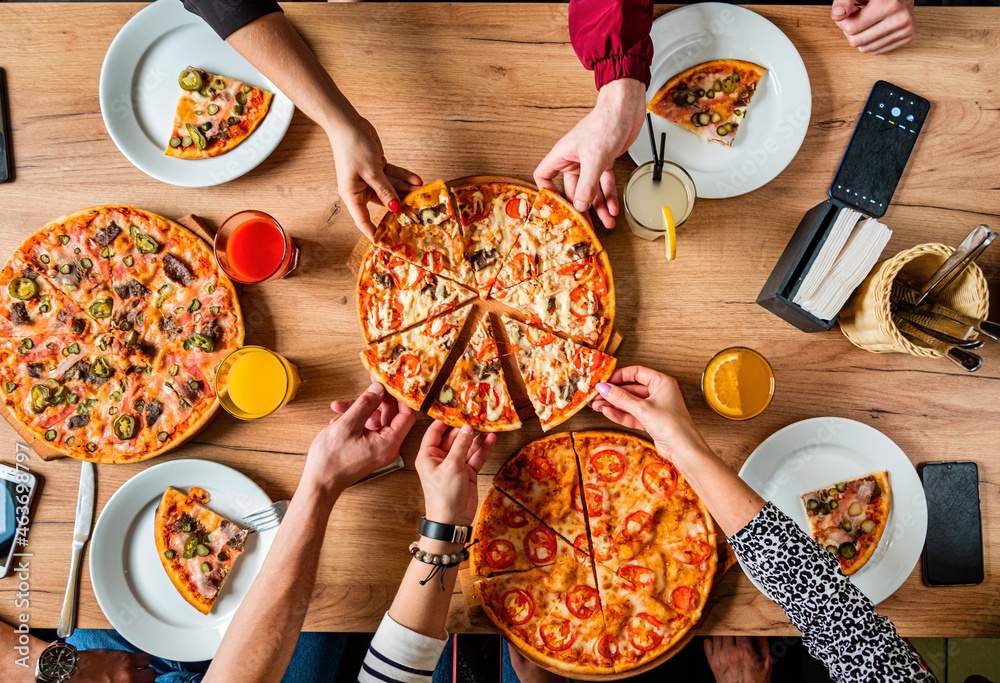 © Maksim Shebeko - Group of people eating pizza.