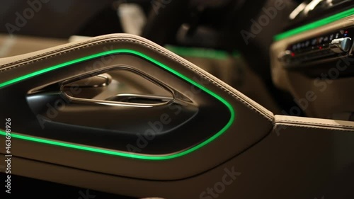 Stitching in the beige interior of a premium car. Atmospheric LED lighting on the arms of the chair.
