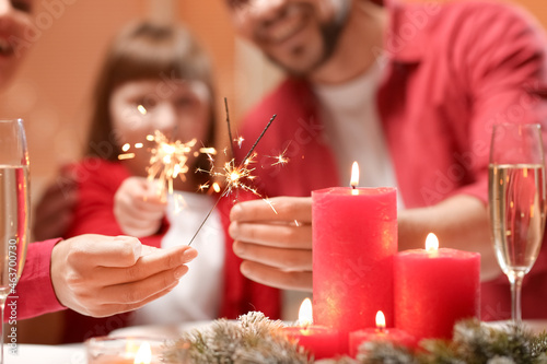 Family with sparklers celebrating Christmas at home