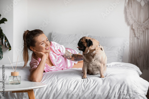 Young woman with cute pug d...