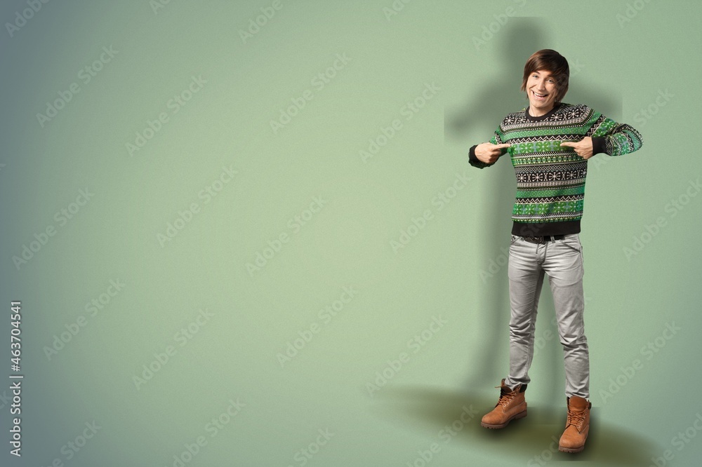 Full length portrait of smiling young handsome man pointing fingers Full length portrait of smiling young handsome man pointing fingers
