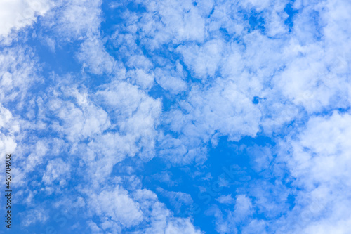 White fluffy clouds floating over sunny blue sky. Beautiful scene of pure nature fuzzy cloudscape. Abstract cloudy background, purity breeze environment. Fresh air with daylight. Freedom concept.