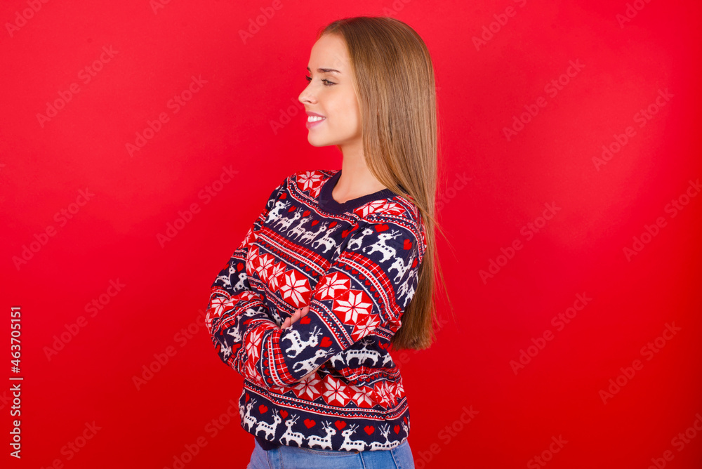 Young caucasian girl wearing christmas sweaters on red background cross hands look copy space Young caucasian girl wearing christmas sweaters on red background cross hands look copy space