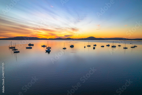 Aerial sunrise waterscape with boats and high cloud
