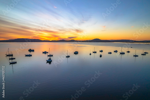 Aerial sunrise waterscape with boats and high cloud
