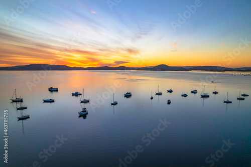 Aerial sunrise waterscape with boats and high cloud
