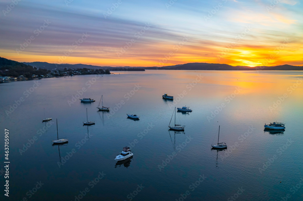 Fototapeta premium Aerial sunrise waterscape with boats and high cloud