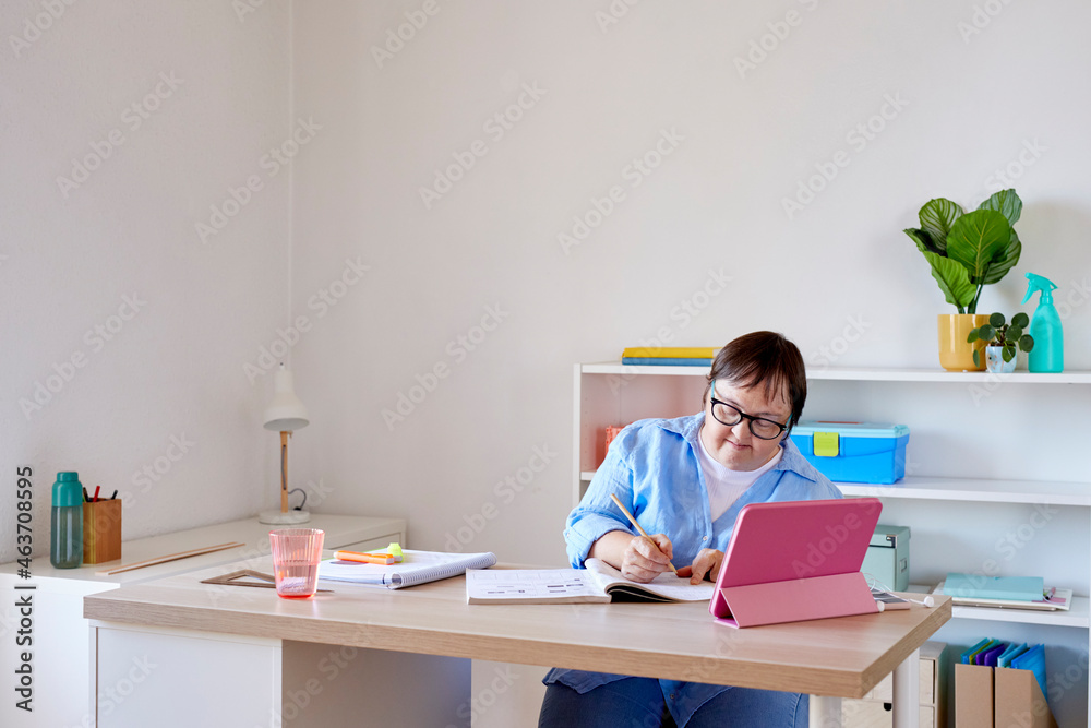 Woman with Down syndrome studying at home Woman with Down syndrome studying at home