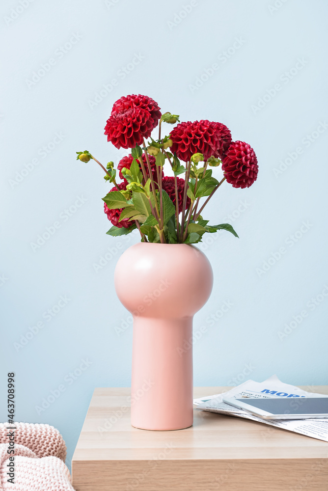 Vase with beautiful dahlias, newspapers and tablet computer on table in room - obrazy, fototapety, plakaty 
