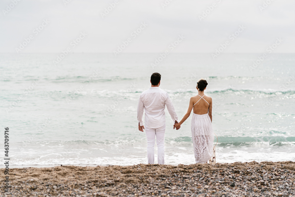 Rear view of the couple at sea looking at the horizon Rear view of the couple at sea looking at the horizon