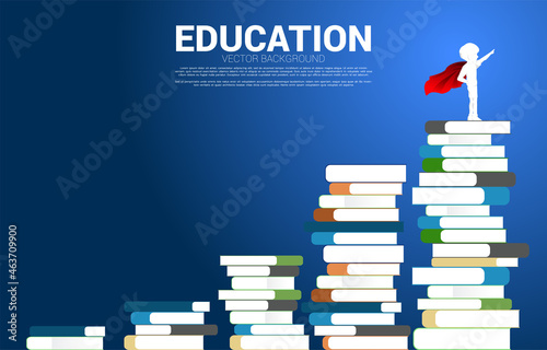 Concept background for power of knowledge. Silhouette of boy in superhero suit standing on stack of books.