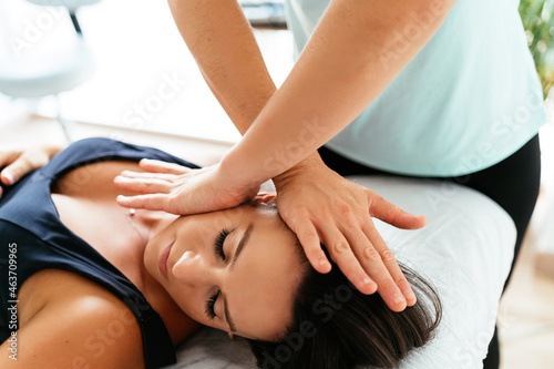 Masseuse treating woman in clinic photo