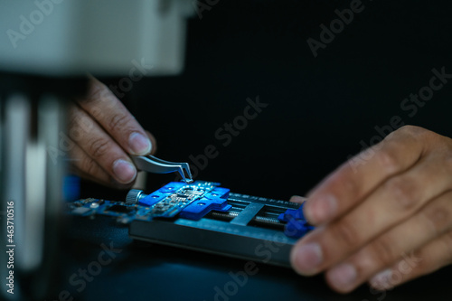 Crop technician installing microchip under microscope photo
