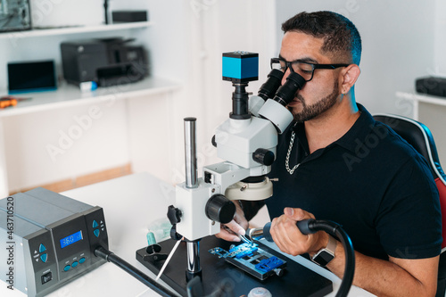 Male worker removing microchip with precision photo