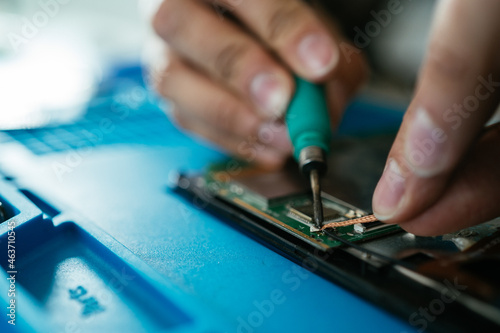 Unrecognizable engineer soldering micro scheme photo