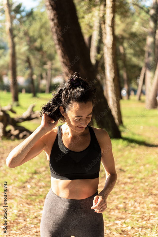 adult Caucasian woman exercising on a mat in the forest adult Caucasian woman exercising on a mat in the forest