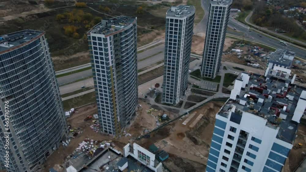 Construction of modern multi-storey buildings. Construction of a new city block. Buildings under construction and tower cranes. Aerial photography in cloudy weather. Construction of modern multi-storey buildings. Construction of a new city block. Buildings under construction and tower cranes. Aerial photography in cloudy weather.