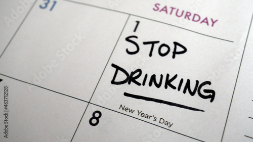 Reminder to stop drinking written on a calendar on New Year's Day as a resolution or for the start of Dry January.