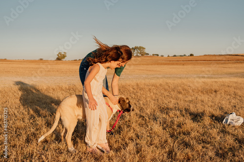 Family caessing their doggy at field photo