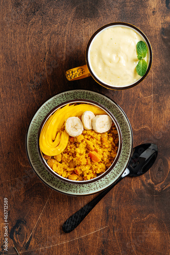 Cup of mango lassi and upma with mango on a table photo