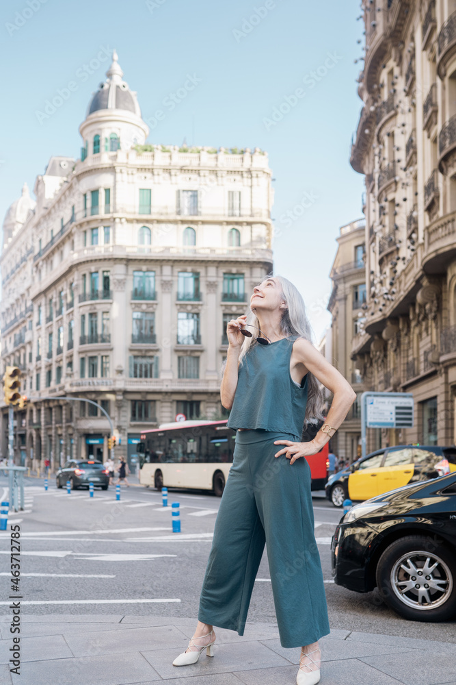 Grey-haired woman standing in the middle of the city Grey-haired woman standing in the middle of the city
