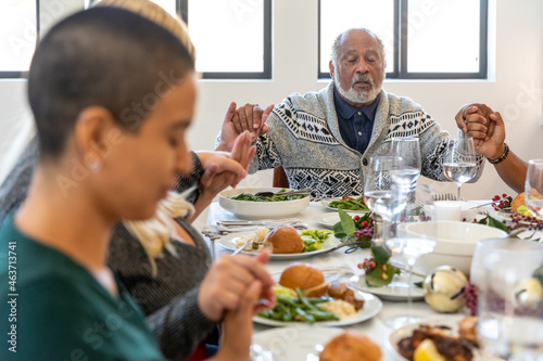 Older Man Says Grace During Holiday Dinner photo
