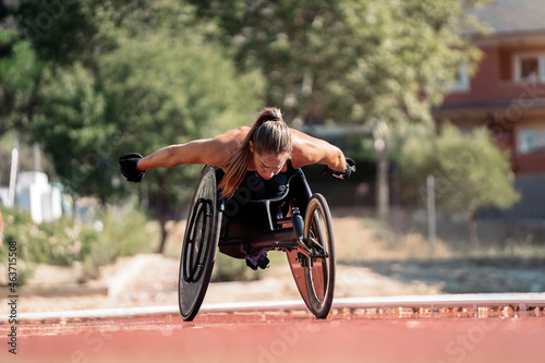 Female wheelchair athlete adjusting her chair on sports track photo