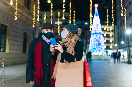 Mature couple using smartphone on street photo