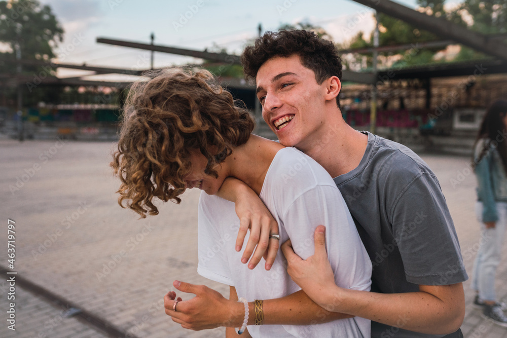 Cheerful guy hugging friend Cheerful guy hugging friend
