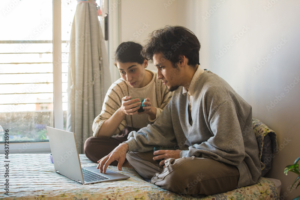 Latino couple using internet in bed Latino couple using internet in bed