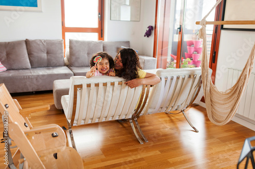 mother and daughter cuddling at living room