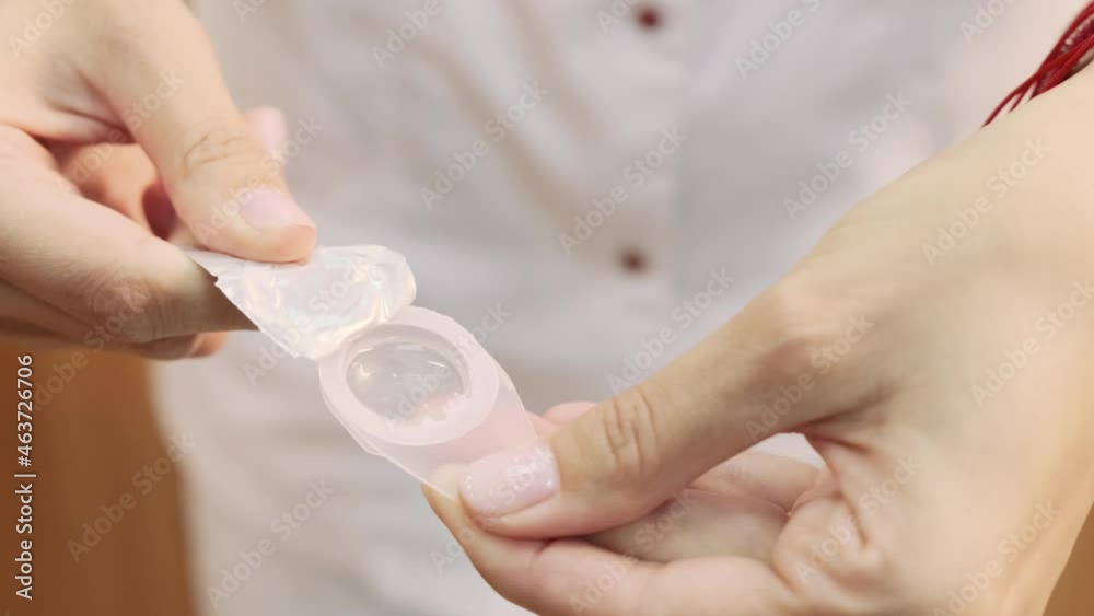 Women's hands open the lens solution. Blurred vision at a young age. Slow motion. Close-up of a hand.
Women's hands open the lens solution. Blurred vision at a young age. Slow motion. Close-up of a hand.