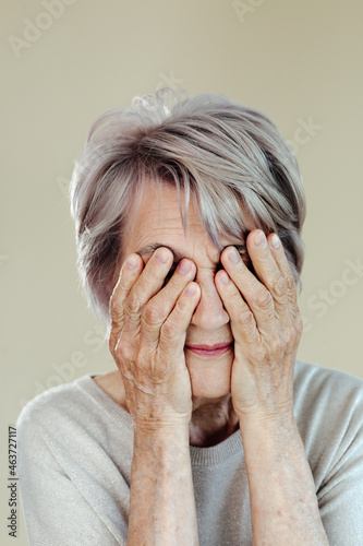 Senior woman covering eyes with hands
