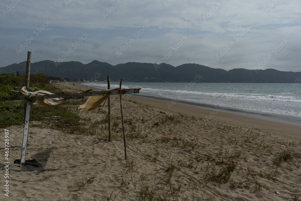 Landscape of a beach with a small stand in the foreground and a mountain in the background