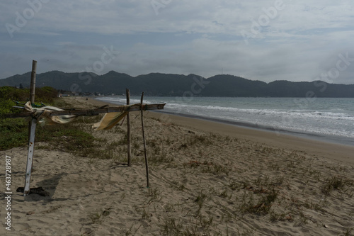 Landscape of a beach with a small stand in the foreground and a mountain in the background