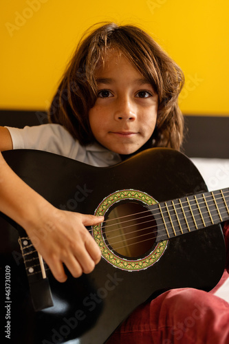 Young boy playing an acoustic guitar 