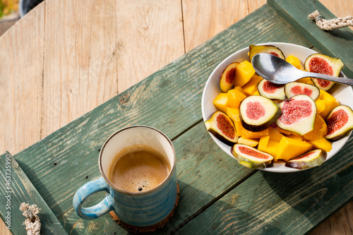 Above shot of fruit salad bowl and coffe cup on table photo