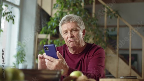  Grandpa is examining a new phone and he is very impressed