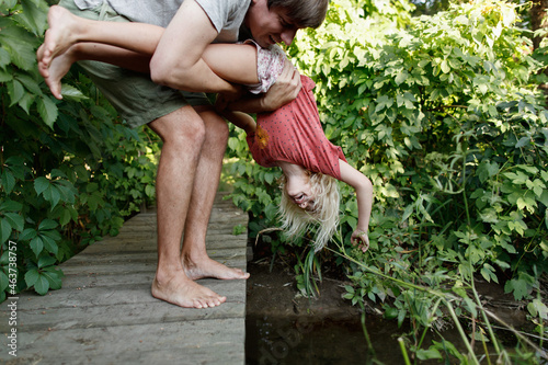Father holding his daughter upside down photo