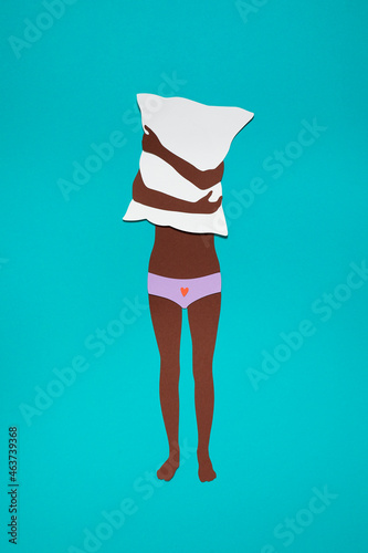 Female adolescent hiding behind a pillow