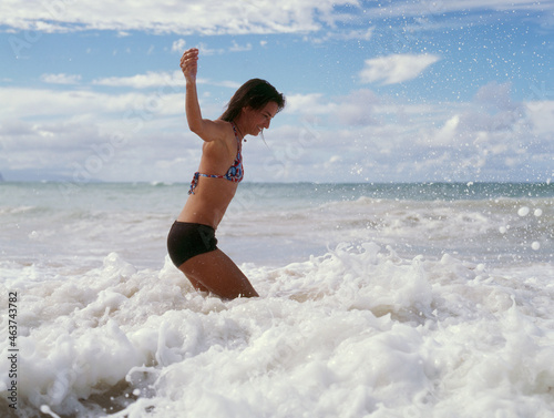 Woman jumping on ocean waves photo