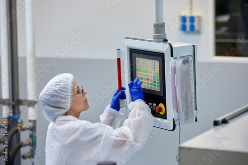 Scientist operating industrial machine at factory photo