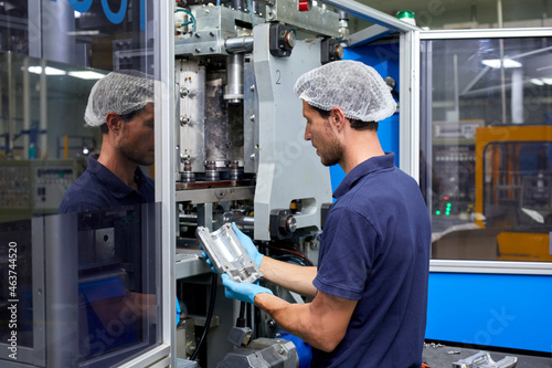 Man fixing extrusion blow molding machine photo