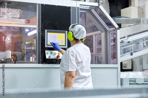 Factory worker operating machine on plant