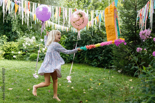 A birthday girl in the garden  with pinata photo