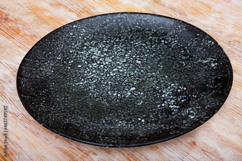 View of empty round black plate on wooden table