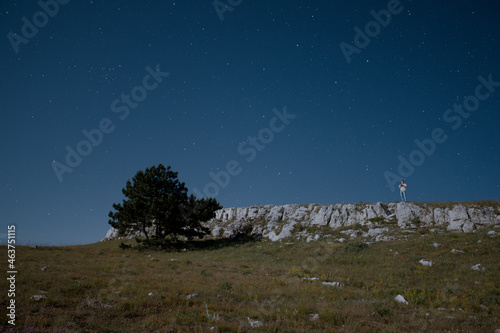 Mountain plateau with figure of man at starry night