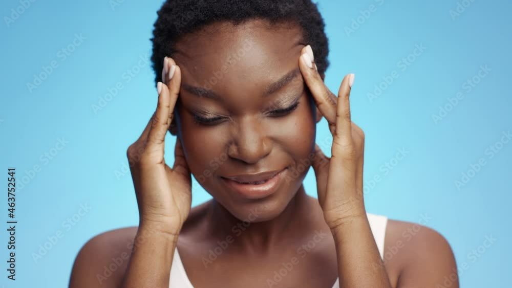 Migraine syndrome. Studio portrait of upset african american lady suffering from headache attack, massaging temples