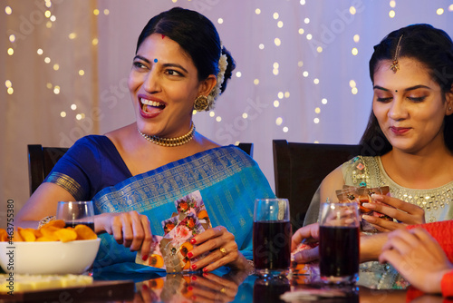 Family members having fun while playing cards on dining table on the occasion of Diwali  photo