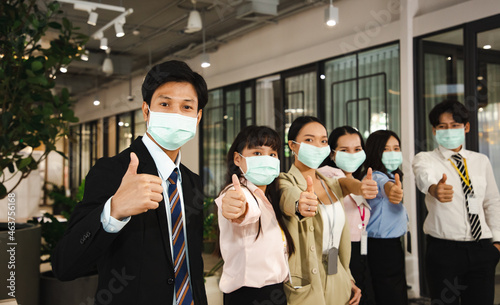 Group of business people with businessman leader wear surgical mask in the office. Sucessful projects and congratulation. Creating a new business in the New narmal. photo